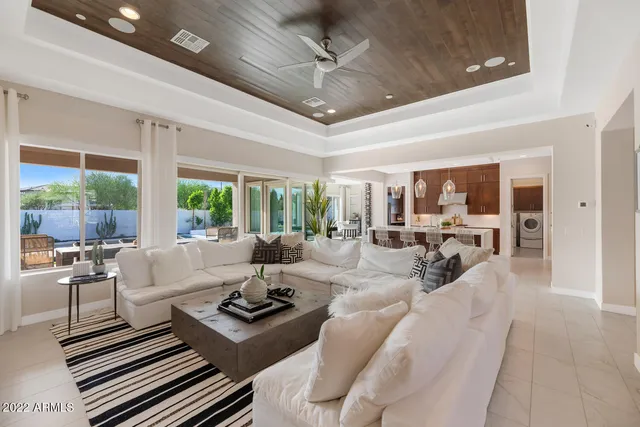 a living room with furniture ceiling fan and a large window
