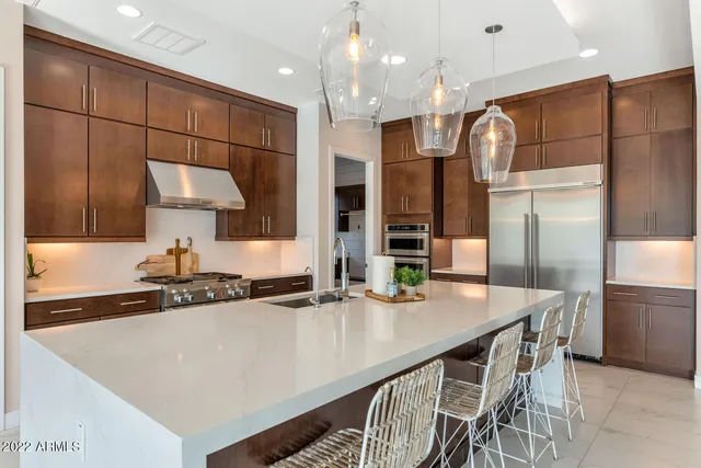 a kitchen with stainless steel appliances granite countertop a sink a stove and a refrigerator