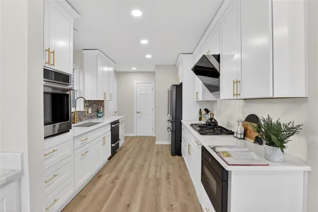 a kitchen with a sink a stove and cabinets