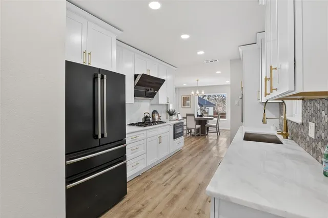 a kitchen with stainless steel appliances kitchen island granite countertop a refrigerator and a sink