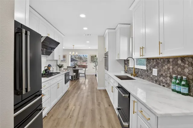 a large kitchen with stainless steel appliances and a counter space