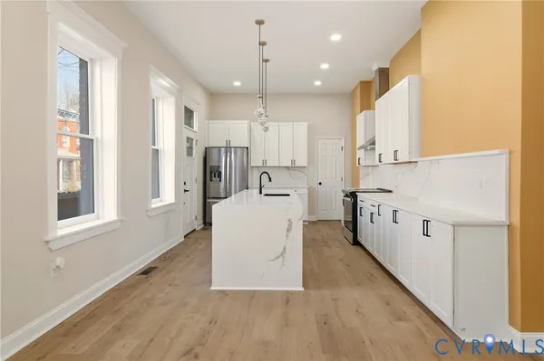 a kitchen with white cabinets and stainless steel appliances