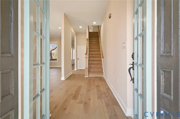 a view of a hallway with wooden floor and staircase