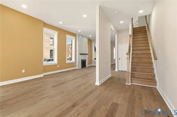 an empty room with wooden floor and windows