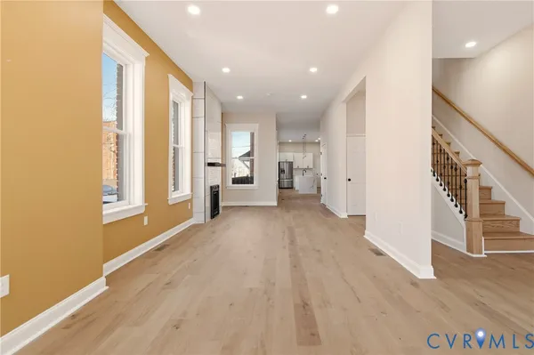 a view of a living hall with wooden floor and windows