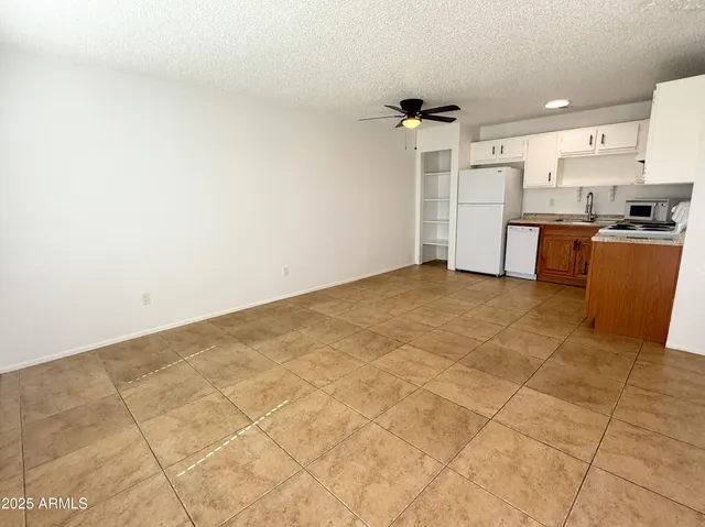a view of kitchen with refrigerator and cabinets