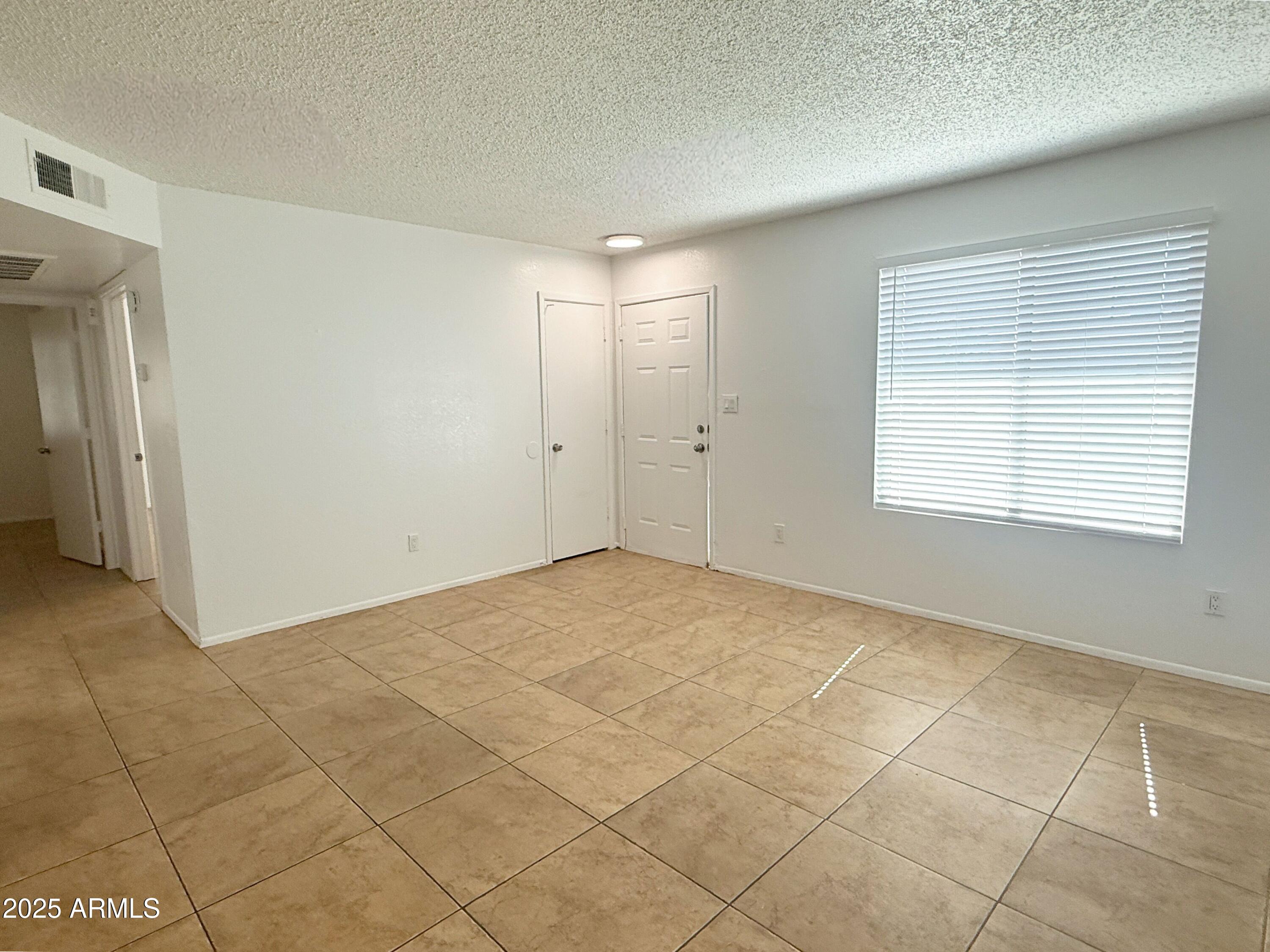 498 East Mesquite Avenue, Unit 4 Apache Junction, AZ 85119 - Photo 4 of 13 a view of an empty room with a window