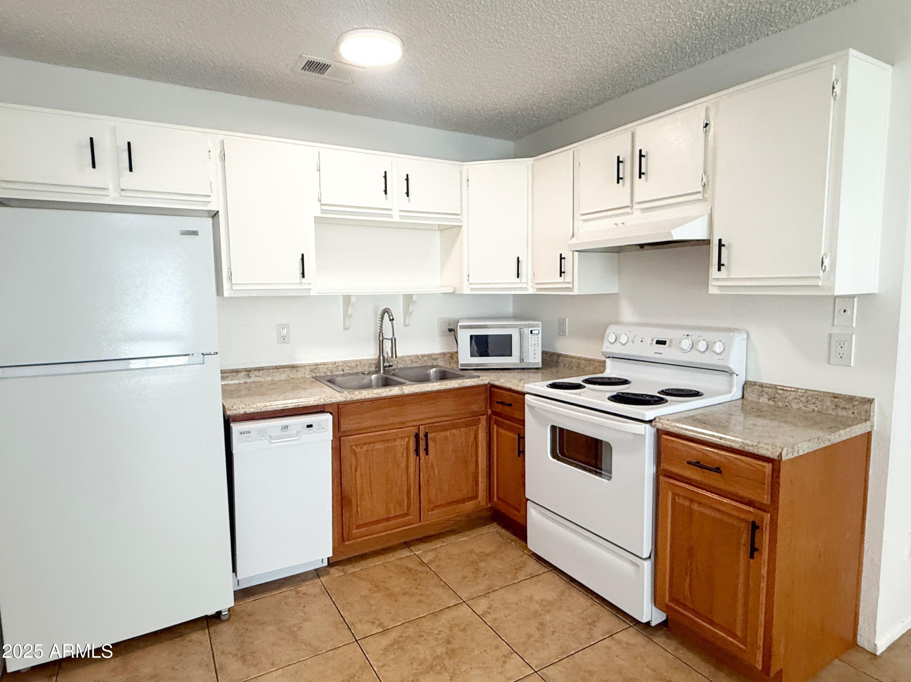 498 East Mesquite Avenue, Unit 4 Apache Junction, AZ 85119 - Photo 6 of 13 a kitchen with cabinets appliances a sink and a counter top space