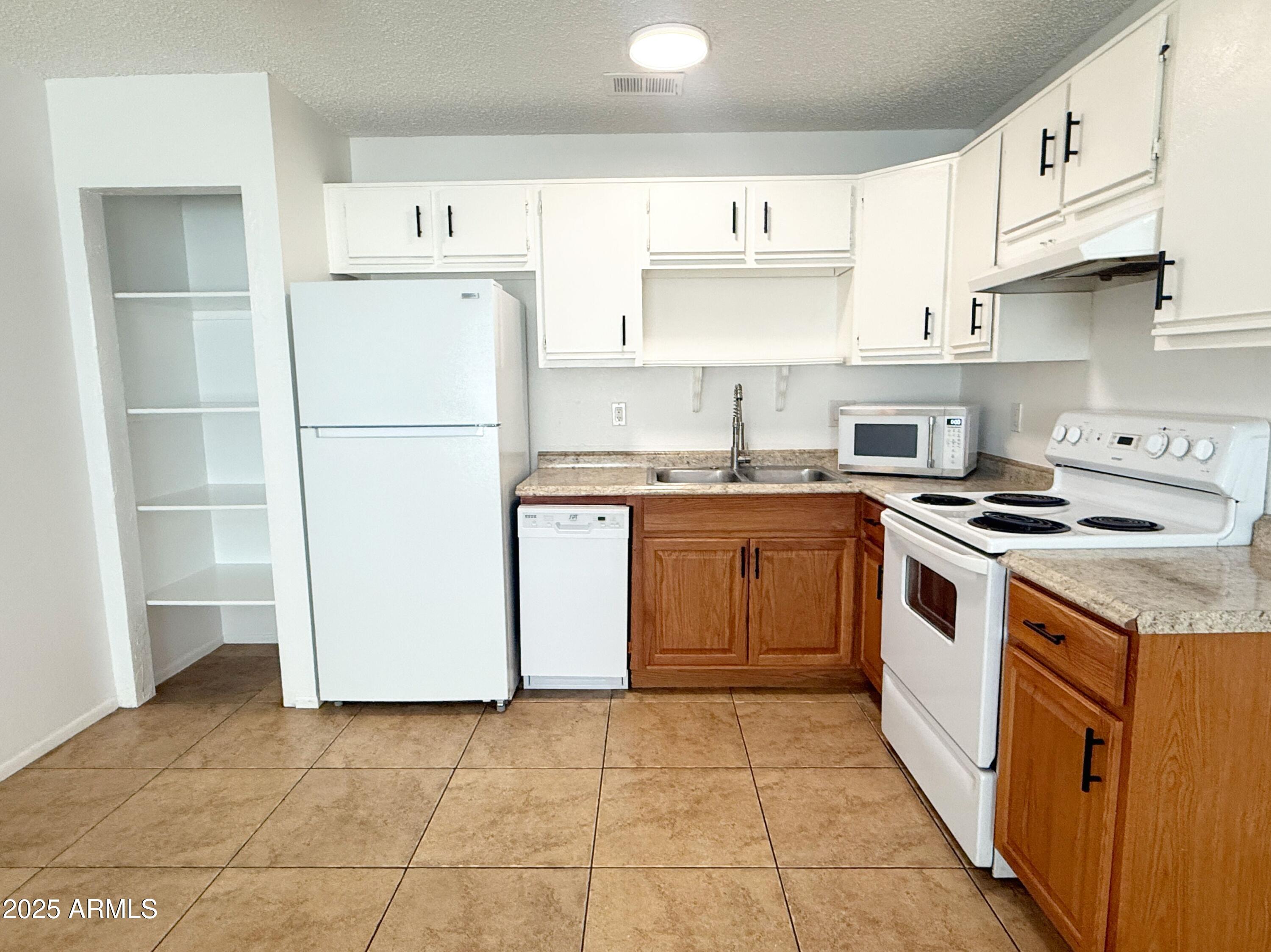 498 East Mesquite Avenue, Unit 4 Apache Junction, AZ 85119 - Photo 7 of 13 a kitchen with a stove sink and a refrigerator