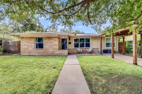 a view of a house with a yard and potted plants