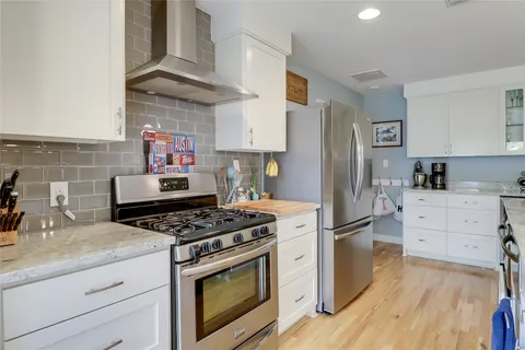 a kitchen with granite countertop a white stove top oven and cabinets