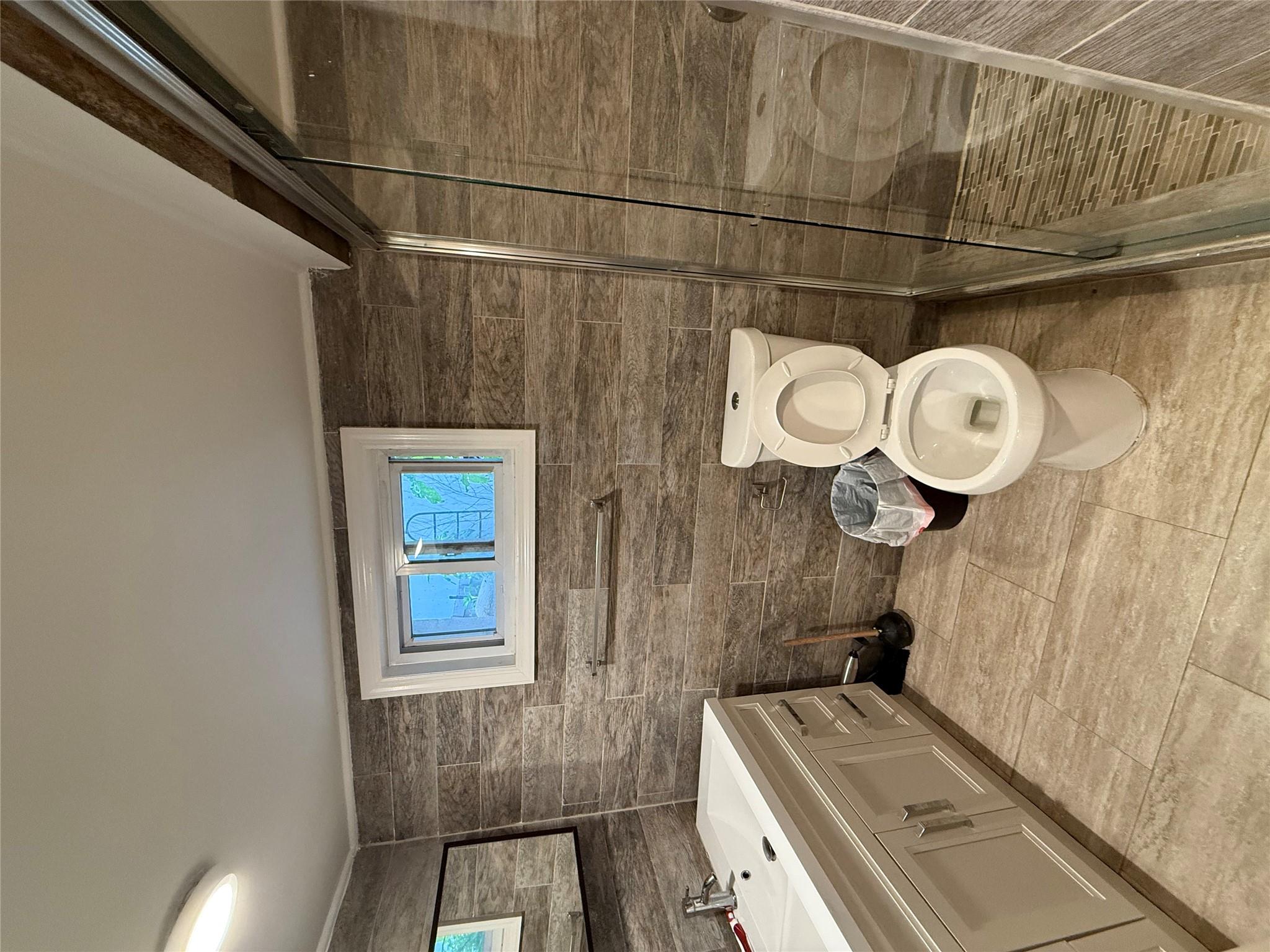 75-22 190th Street Queens, NY 11366 - Photo 10 of 10 Bathroom featuring vanity, toilet, a stall shower, tile patterned floors, and crown molding