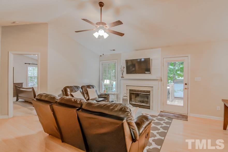 8640 Harps Mill Road Raleigh, NC 27615 - Photo 4 of 23 a living room with furniture a fireplace and a flat screen tv