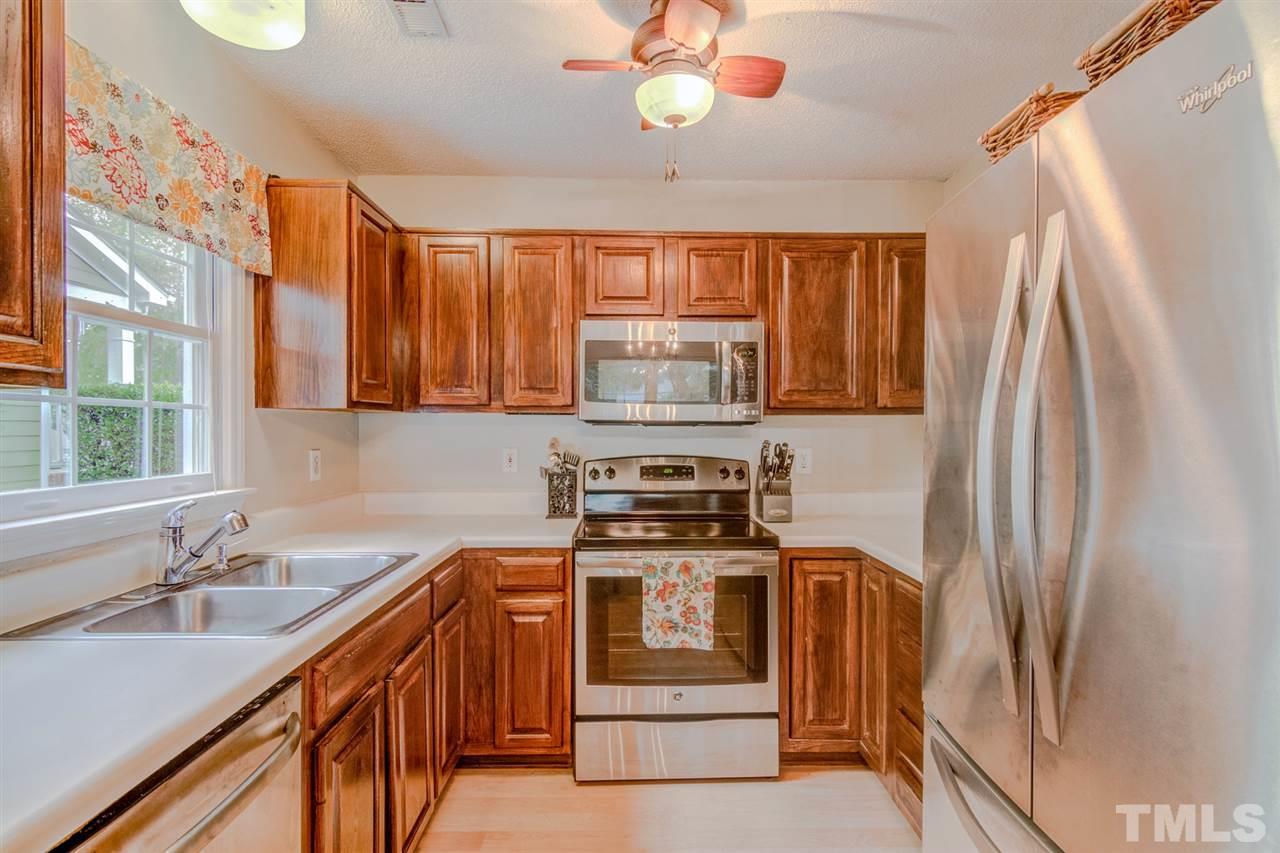 8640 Harps Mill Road Raleigh, NC 27615 - Photo 9 of 23 a kitchen with stainless steel appliances a stove a sink and a refrigerator