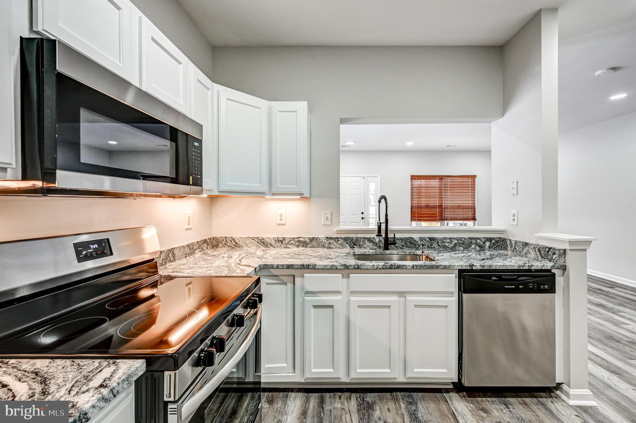 300 Roff Point Drive Odenton, MD 21113 - Photo 11 of 28 a kitchen with stainless steel appliances granite countertop a stove and a microwave