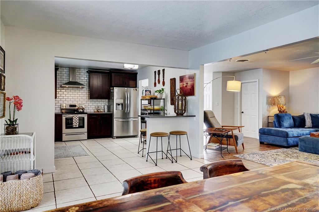 905 Southeast Flamingo Avenue Stuart, FL 34996 - Photo 13 of 36 a living room with furniture and a kitchen view