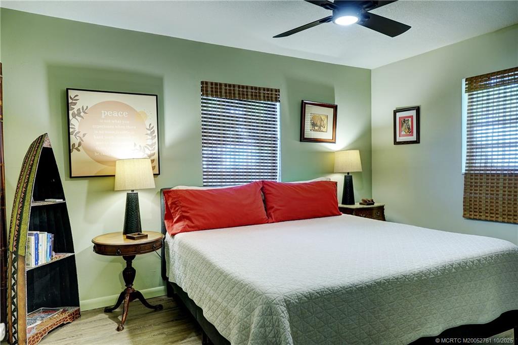 905 Southeast Flamingo Avenue Stuart, FL 34996 - Photo 17 of 36 a bedroom with a bed and a chandelier