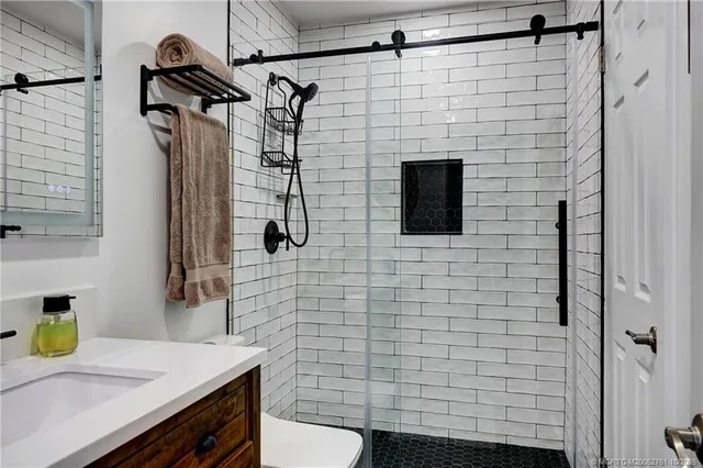 a bathroom with a sink a toilet and shower