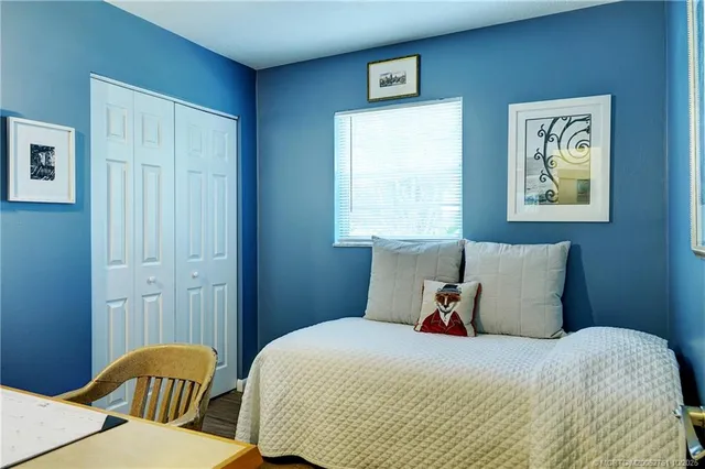 a bedroom with a bed and painting on the wall