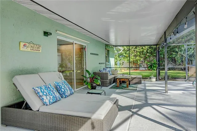 a living room with furniture and a floor to ceiling window