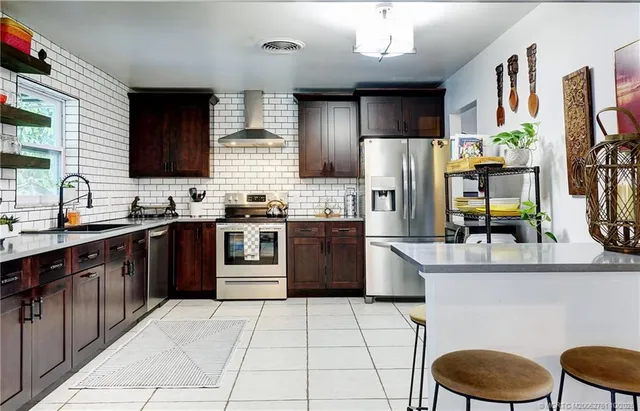a kitchen with stainless steel appliances granite countertop a stove refrigerator and sink