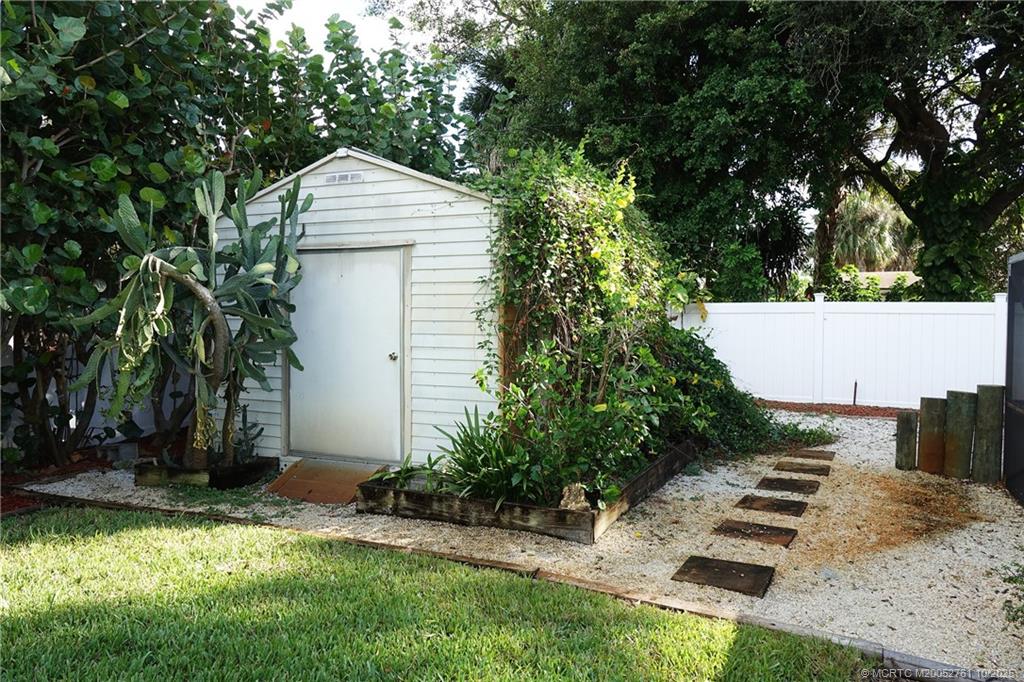 905 Southeast Flamingo Avenue Stuart, FL 34996 - Photo 32 of 36 a backyard of a house with plants and trees