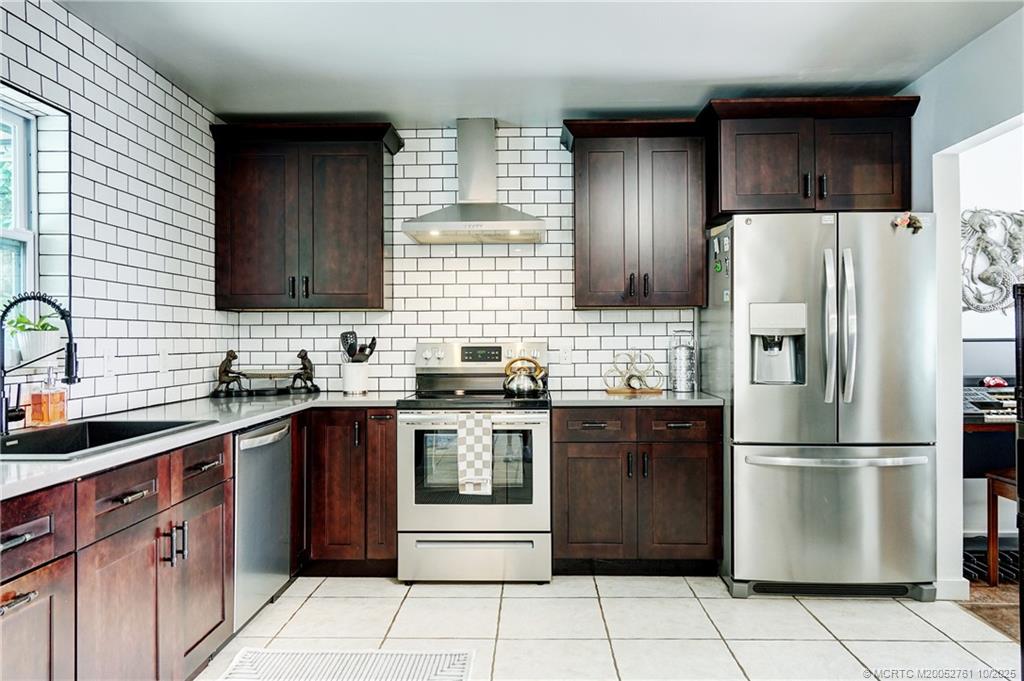 905 Southeast Flamingo Avenue Stuart, FL 34996 - Photo 6 of 36 a kitchen with stainless steel appliances granite countertop a refrigerator stove a sink and dishwasher