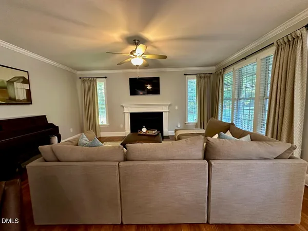 a living room with furniture a fireplace and a flat screen tv