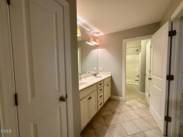 a bathroom with a double vanity sink a mirror and a shower