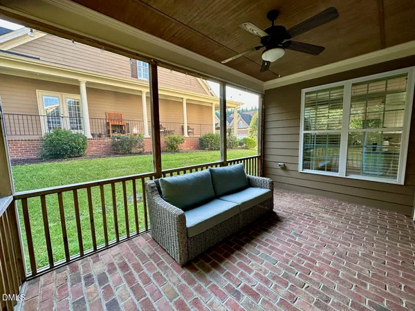 a view of a porch with furniture and a garden