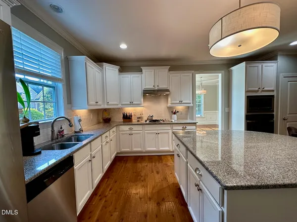 a kitchen with kitchen island granite countertop a sink appliances cabinets and a counter top space