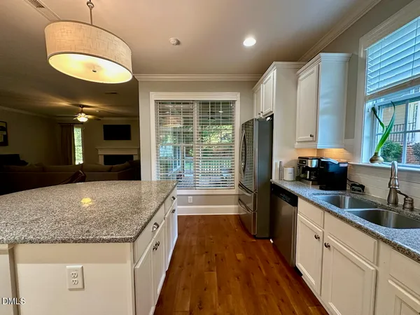 a kitchen with stainless steel appliances granite countertop a sink and a refrigerator