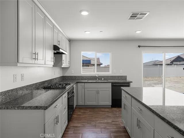 a kitchen with stainless steel appliances granite countertop sink stove and cabinets