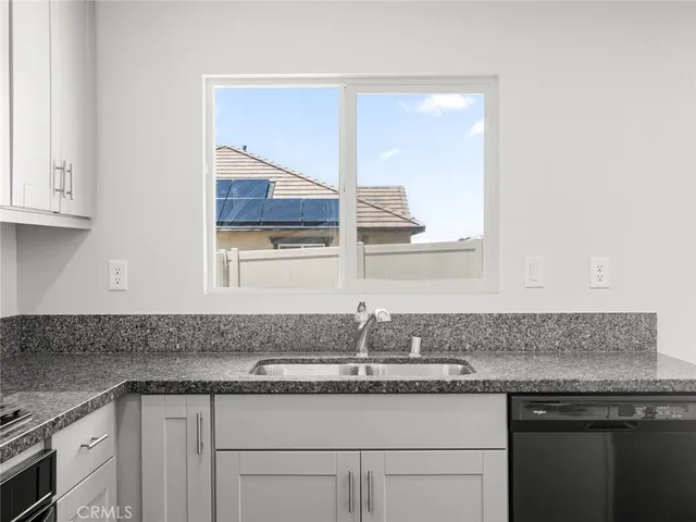 a kitchen with granite countertop a sink and cabinets