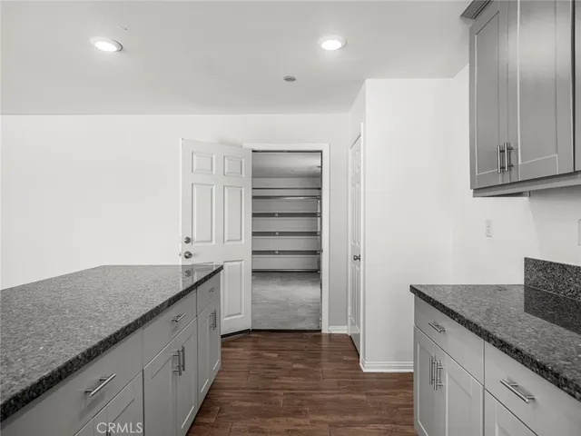 a kitchen with granite countertop a sink and a stove