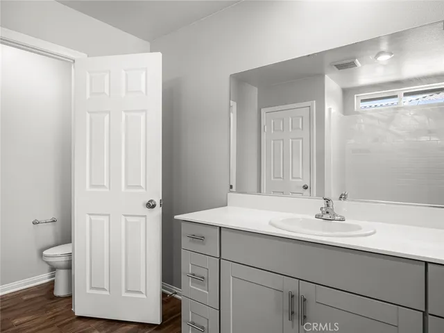 a bathroom with a sink a toilet and a mirror