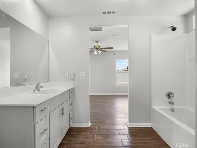 a bathroom with a tub sink and mirror