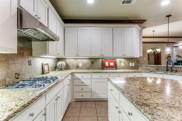 a kitchen with stainless steel appliances granite countertop a sink a stove and a microwave