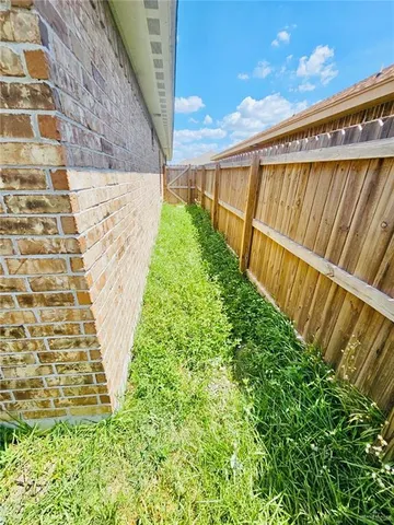 a view of swimming pool with brick wall and wooden fence