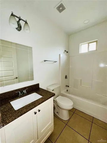 a bathroom with a granite countertop sink a toilet and shower