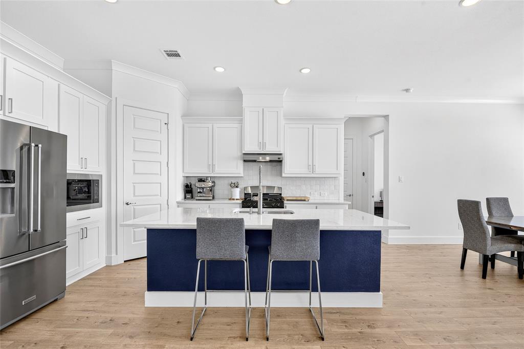 209 Basalt Lane Azle, TX 76020 - Photo 18 of 39 a kitchen with stainless steel appliances kitchen island granite countertop a dining table chairs and a refrigerator