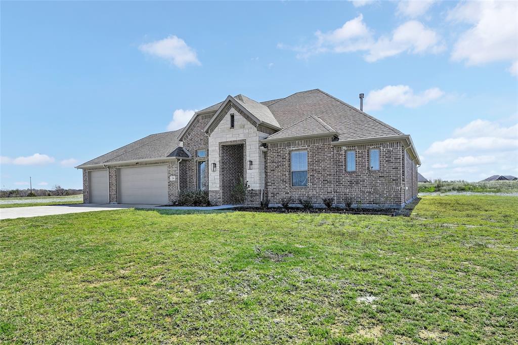 209 Basalt Lane Azle, TX 76020 - Photo 2 of 39 a front view of a house with a garden and yard