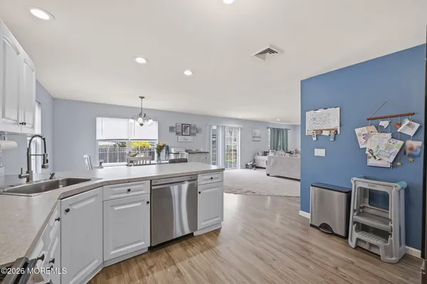 a large kitchen with cabinets wooden floor and stainless steel appliances