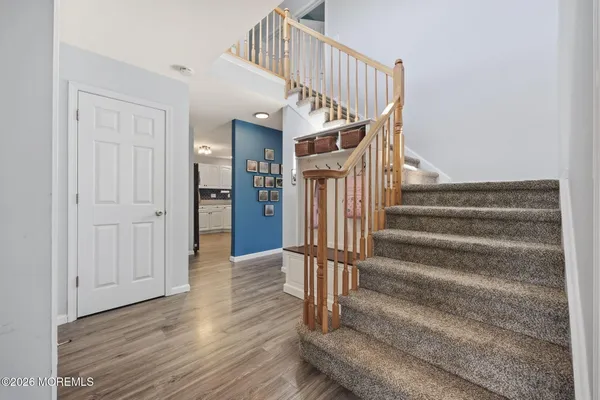 a view of entryway and hall with wooden floor