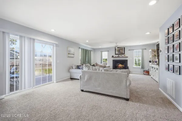 a living room with furniture a fireplace and a large window