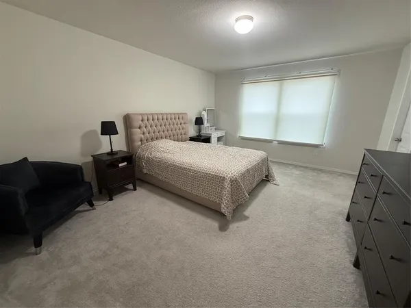 a spacious bedroom with a bed and window