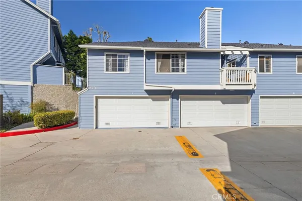 a view of a house with outdoor space and a car parked on the road