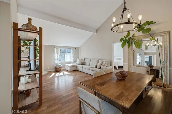 a living room with furniture a chandelier and a dining table
