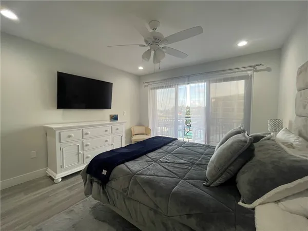 a bedroom with a bed tv and a window