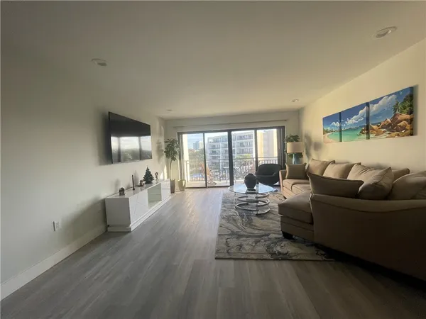 a living room with furniture wooden floor and a flat screen tv